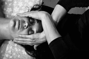 Mains expertes pratiquant le massage facial pour la détente et l’éclat